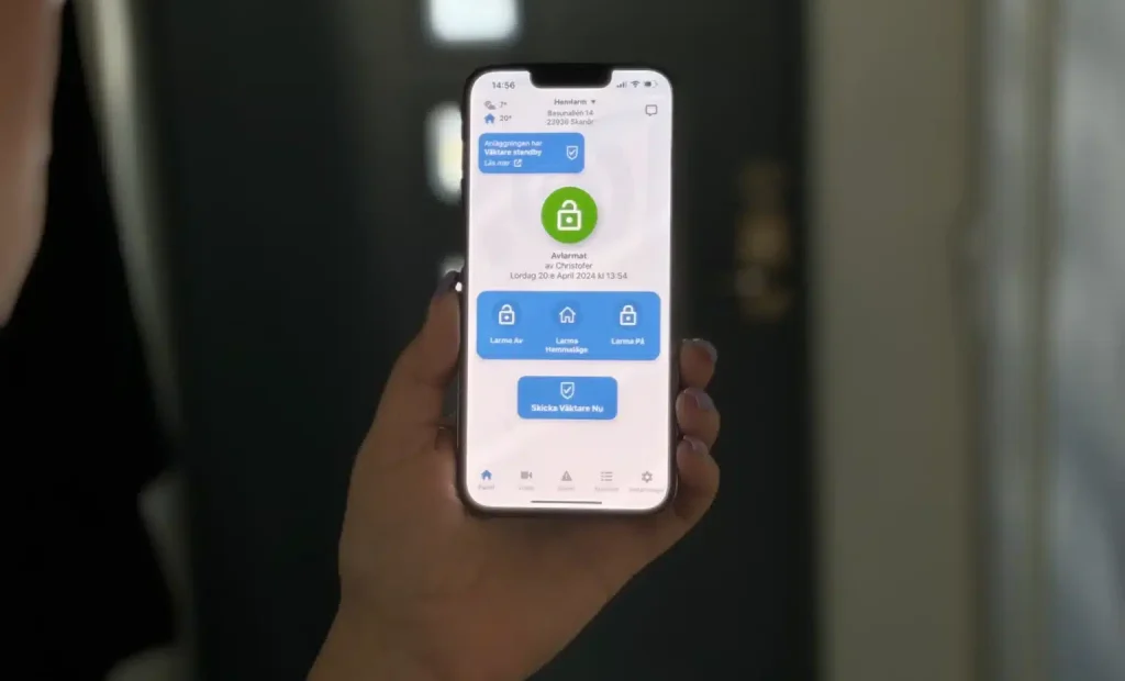 Bild av en person som håller en smartphone som visar larmapp från Svenska Alarm.