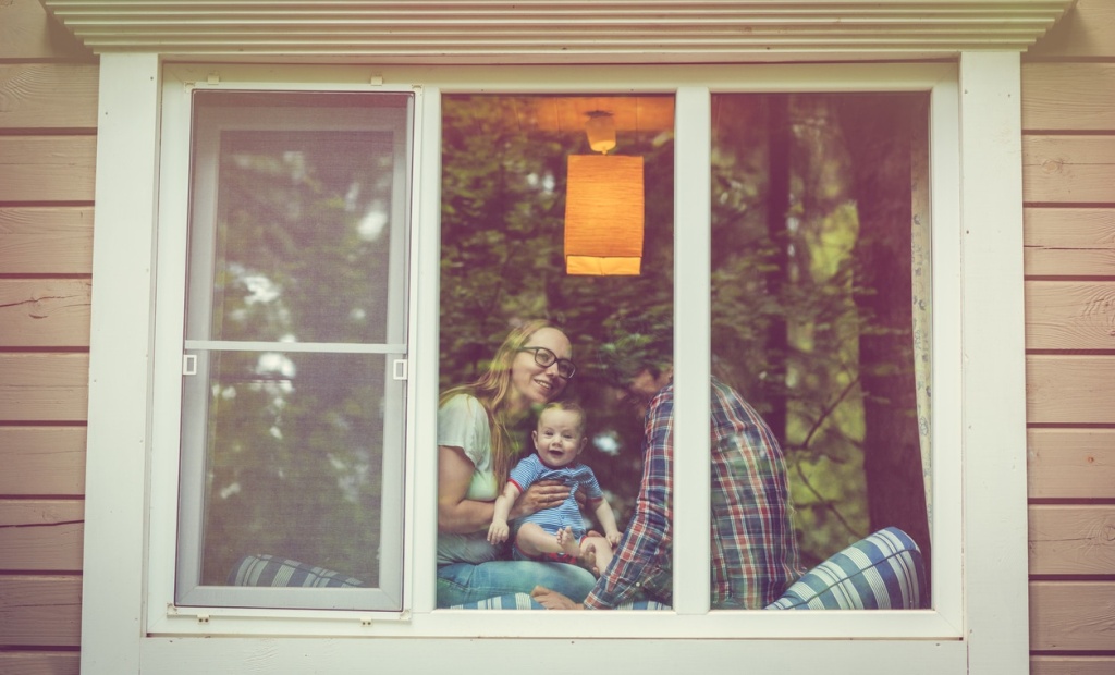 Parents with their baby through a window